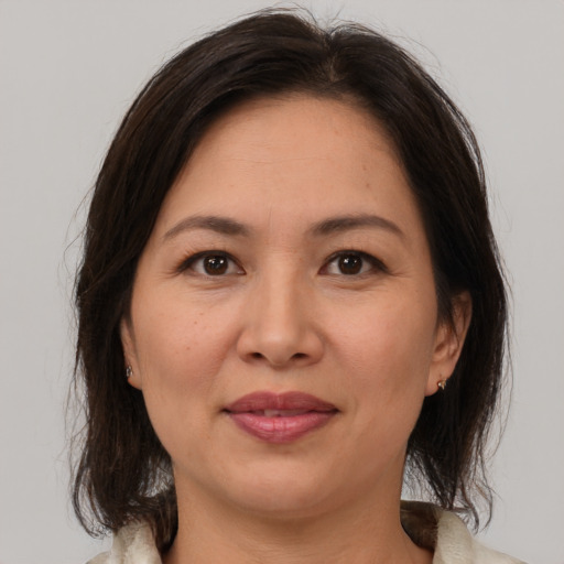 Joyful white adult female with medium  brown hair and brown eyes