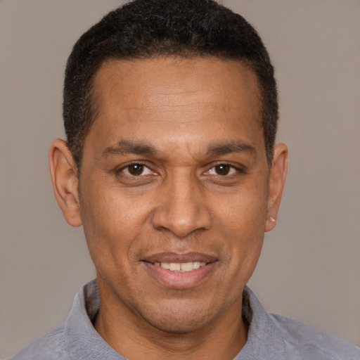 Joyful latino adult male with short  brown hair and brown eyes