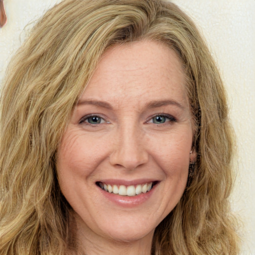 Joyful white adult female with long  brown hair and green eyes