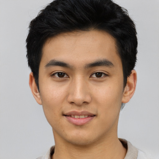 Joyful asian young-adult male with short  black hair and brown eyes