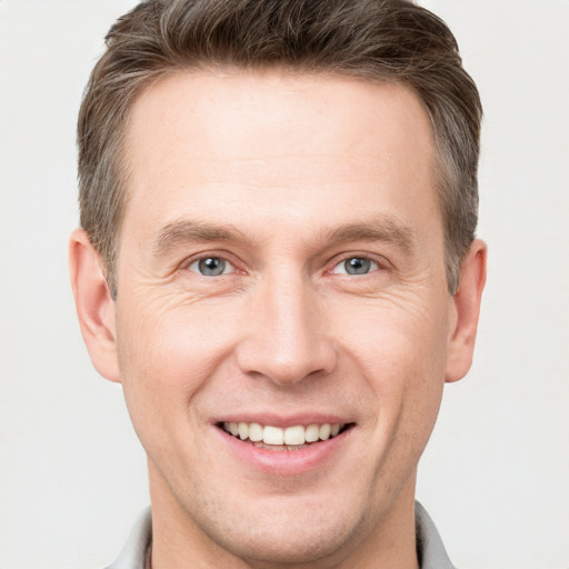 Joyful white adult male with short  brown hair and grey eyes