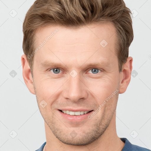 Joyful white young-adult male with short  brown hair and grey eyes