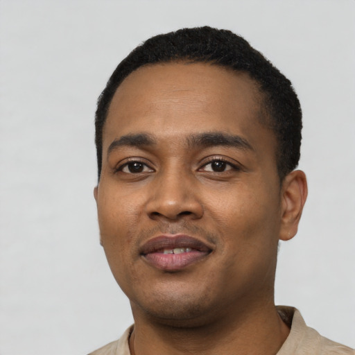 Joyful black young-adult male with short  black hair and brown eyes
