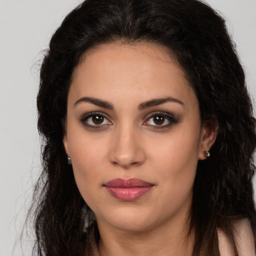 Joyful latino young-adult female with long  brown hair and brown eyes