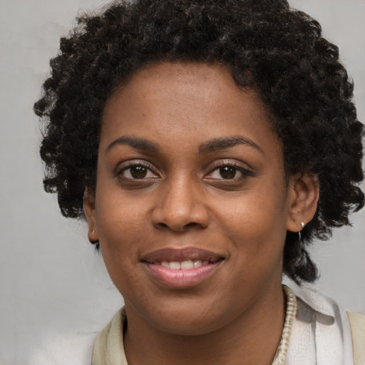 Joyful black young-adult female with short  brown hair and brown eyes