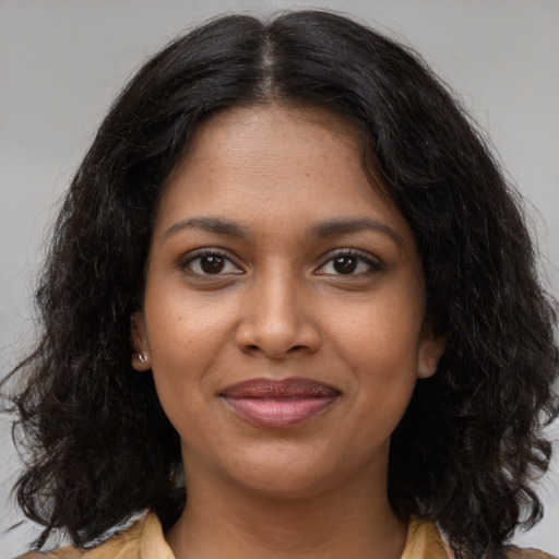 Joyful black young-adult female with long  brown hair and brown eyes