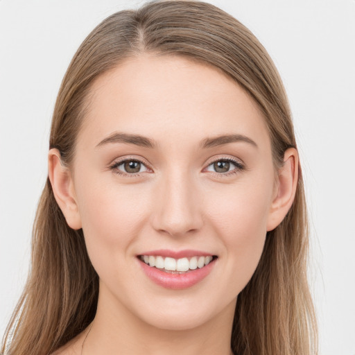 Joyful white young-adult female with long  brown hair and grey eyes