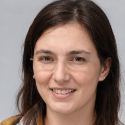 Joyful white adult female with long  brown hair and brown eyes