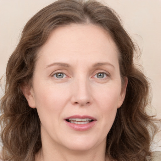 Joyful white young-adult female with long  brown hair and blue eyes