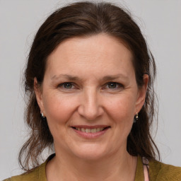 Joyful white adult female with medium  brown hair and grey eyes