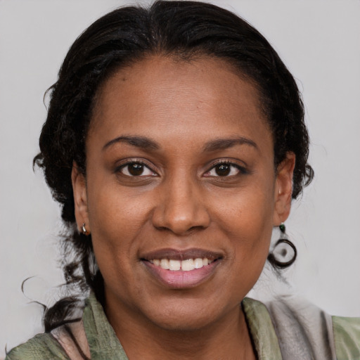 Joyful black adult female with medium  brown hair and brown eyes