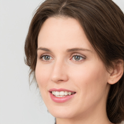 Joyful white young-adult female with medium  brown hair and grey eyes