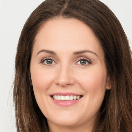 Joyful white young-adult female with long  brown hair and grey eyes