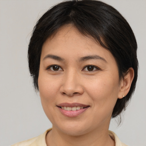 Joyful asian young-adult female with medium  brown hair and brown eyes