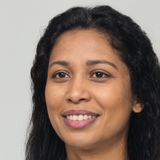 Joyful latino adult female with long  black hair and brown eyes
