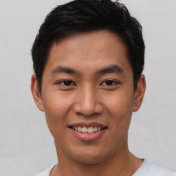 Joyful asian young-adult male with short  black hair and brown eyes