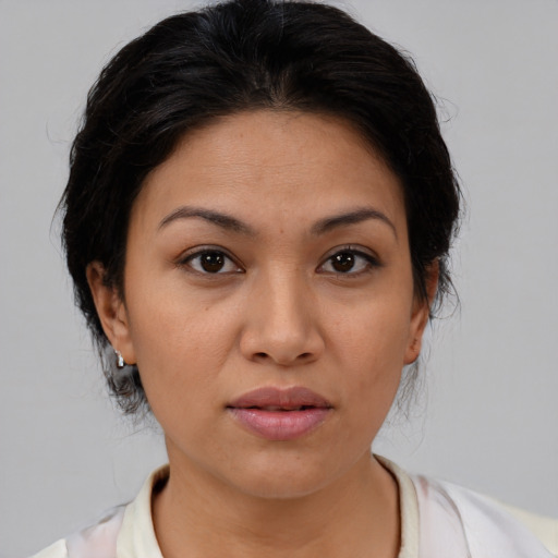 Joyful latino young-adult female with medium  brown hair and brown eyes
