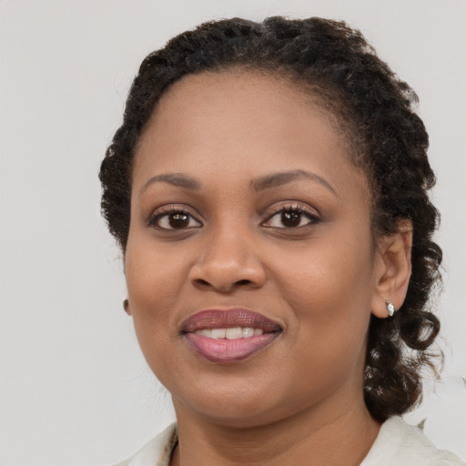 Joyful black young-adult female with medium  brown hair and brown eyes