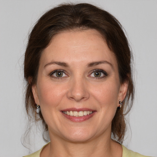 Joyful white young-adult female with medium  brown hair and green eyes