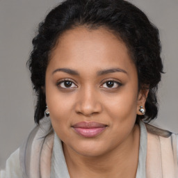 Joyful black young-adult female with long  brown hair and brown eyes