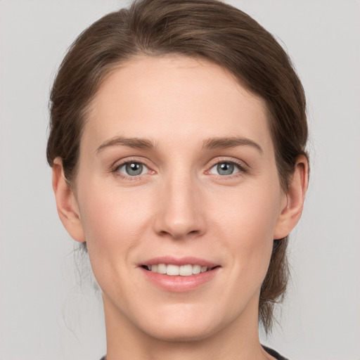 Joyful white young-adult female with medium  brown hair and grey eyes