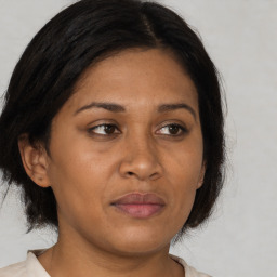 Joyful black adult female with medium  brown hair and brown eyes