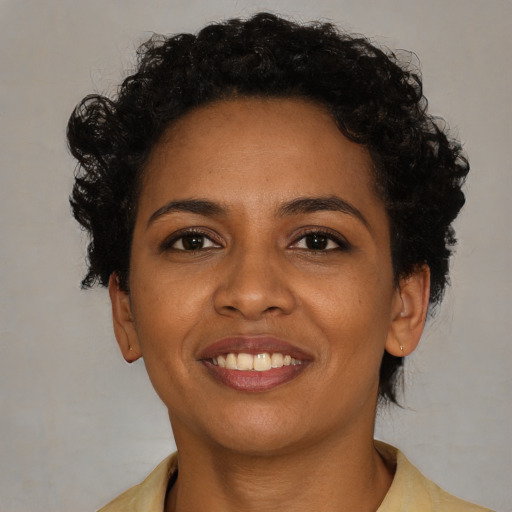 Joyful black young-adult female with short  brown hair and brown eyes