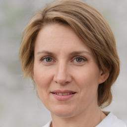 Joyful white adult female with medium  brown hair and blue eyes