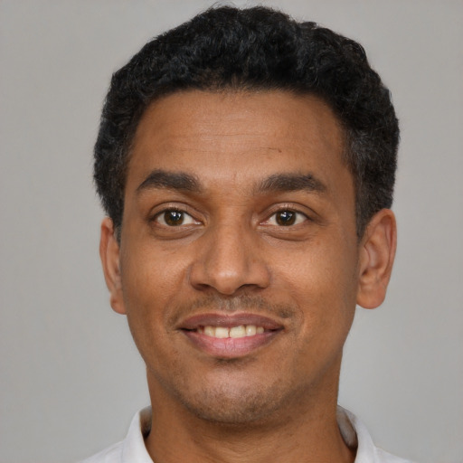 Joyful latino young-adult male with short  black hair and brown eyes