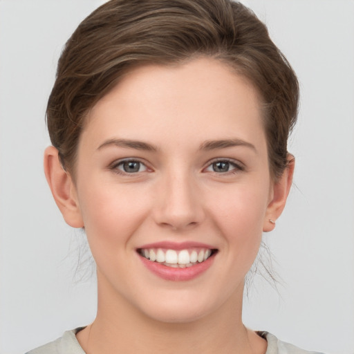 Joyful white young-adult female with medium  brown hair and grey eyes