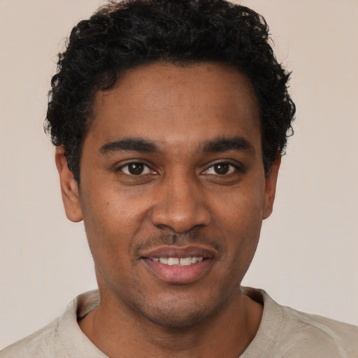 Joyful black young-adult male with short  black hair and brown eyes