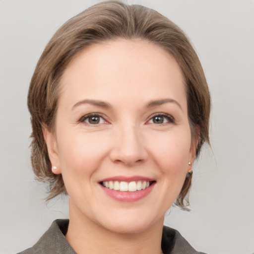 Joyful white adult female with medium  brown hair and grey eyes