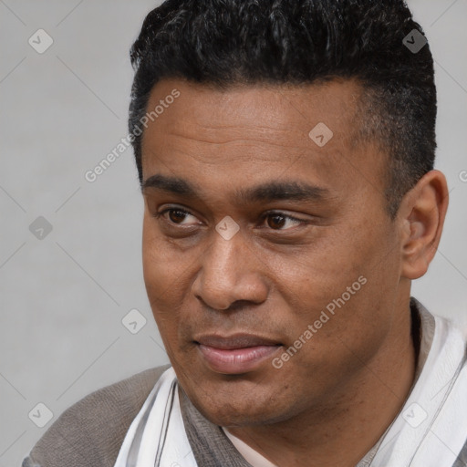 Joyful latino young-adult male with short  black hair and brown eyes