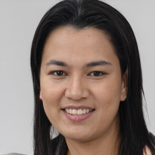 Joyful asian young-adult female with long  brown hair and brown eyes