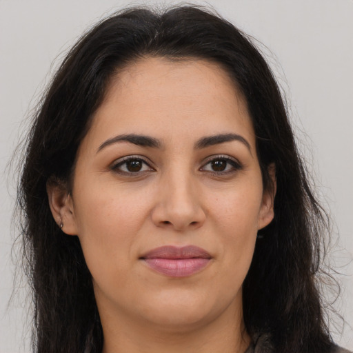 Joyful latino young-adult female with long  brown hair and brown eyes