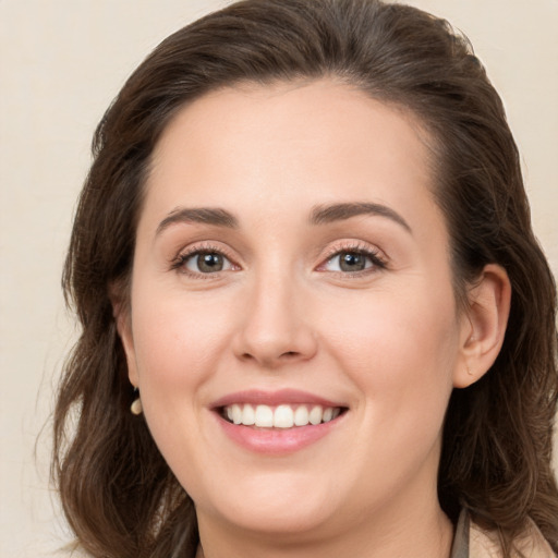 Joyful white young-adult female with medium  brown hair and grey eyes