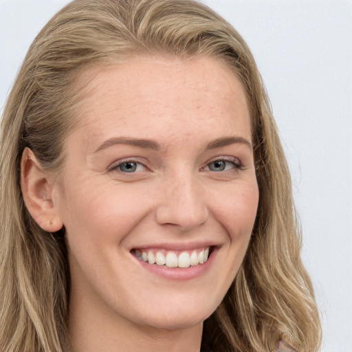 Joyful white young-adult female with long  brown hair and blue eyes