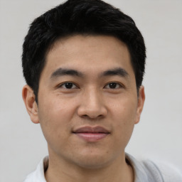 Joyful asian young-adult male with short  black hair and brown eyes