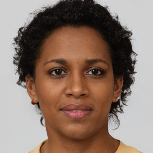 Joyful black young-adult female with short  brown hair and brown eyes