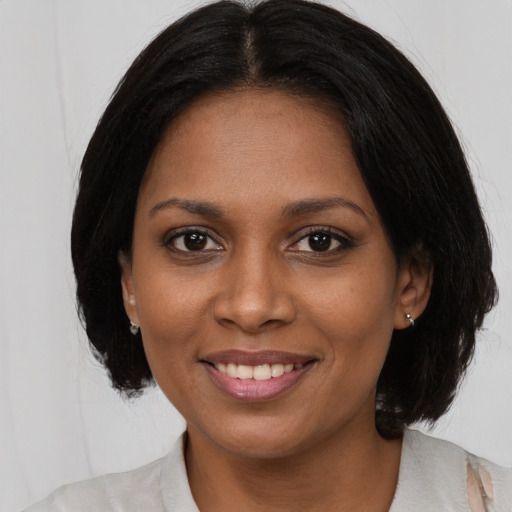 Joyful black young-adult female with medium  brown hair and brown eyes