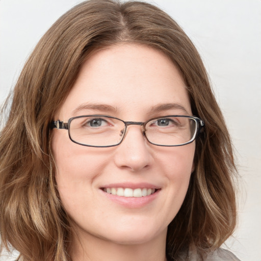 Joyful white young-adult female with long  brown hair and blue eyes