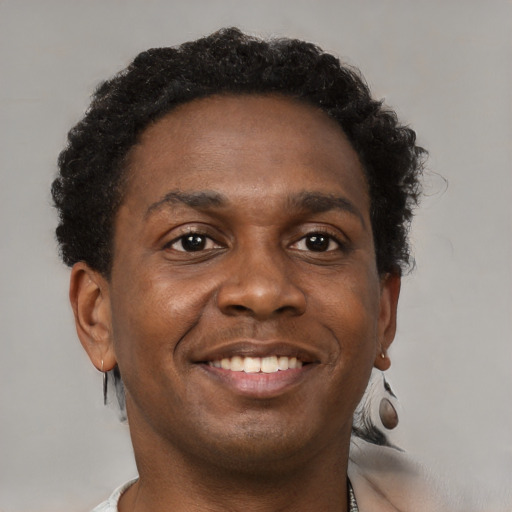 Joyful black young-adult male with short  brown hair and brown eyes