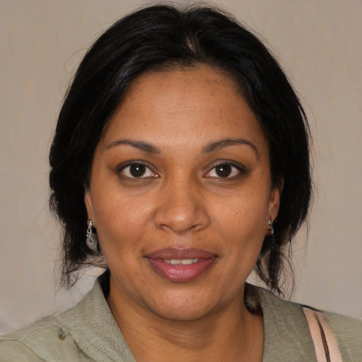 Joyful black adult female with medium  brown hair and brown eyes