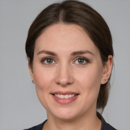 Joyful white young-adult female with medium  brown hair and grey eyes