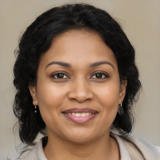 Joyful black young-adult female with medium  brown hair and brown eyes