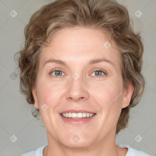 Joyful white adult female with medium  brown hair and blue eyes