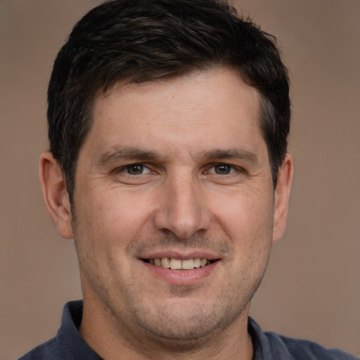 Joyful white adult male with short  brown hair and brown eyes