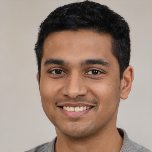 Joyful latino young-adult male with short  black hair and brown eyes