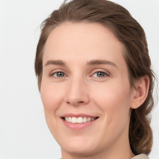 Joyful white young-adult female with medium  brown hair and green eyes