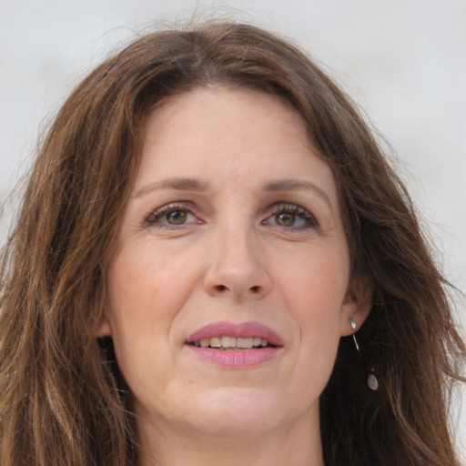 Joyful white adult female with long  brown hair and grey eyes